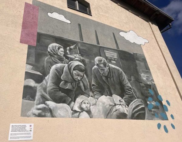 Mural w tonacji czarno-białej przedstawiający uchodźców